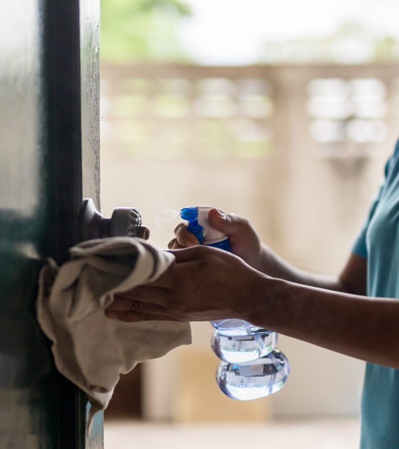 woman-cleaning-door-knob-with-alcohol-spray-for-co-2025-10-16-06-12-09-utc